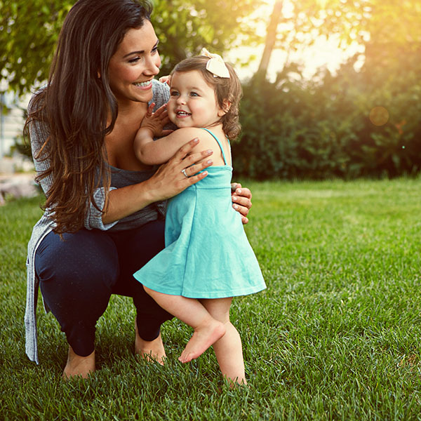 Mother playing with her little daughter outside in the yard in Morris, NJ